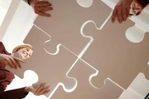 people holding gray puzzle pieces