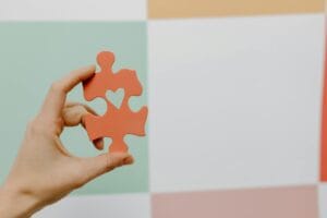 close up of person holding a puzzle piece with a heart
